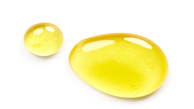 2 yellow oils drops on a white background